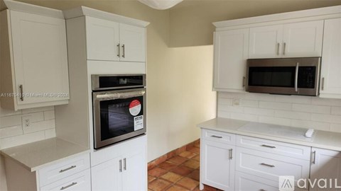 A kitchen with white cabinets and a black oven.