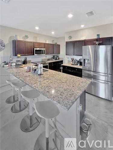 A kitchen with granite countertops and stainless steel appliances.