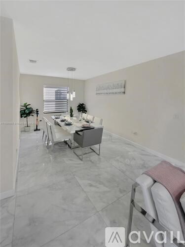 A modern dining room with a marble floor and a glass table.