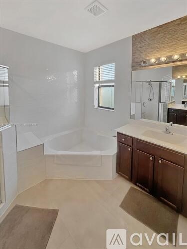 A bathroom with a brown rug on the floor.