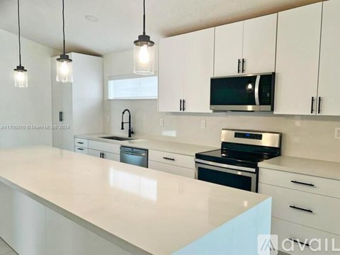 A modern kitchen with white cabinets and a white countertop.