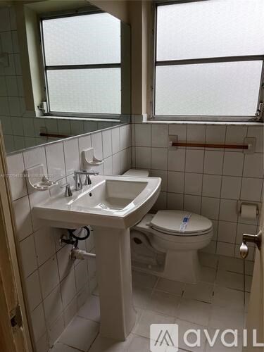 A small white sink in a small bathroom.