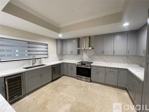 A kitchen with a stove top oven and a sink.