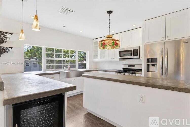 A modern kitchen with stainless steel appliances and white cabinets.