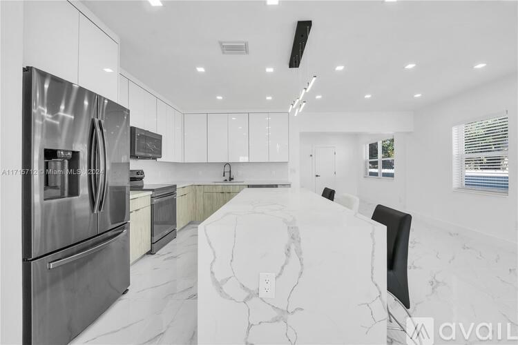A modern kitchen with stainless steel appliances and marble countertops.