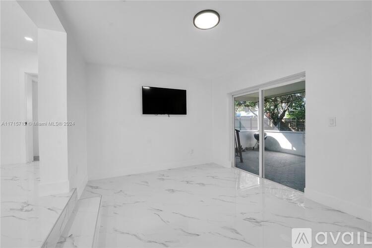 A room with a flat screen TV mounted on the wall and a marble floor.