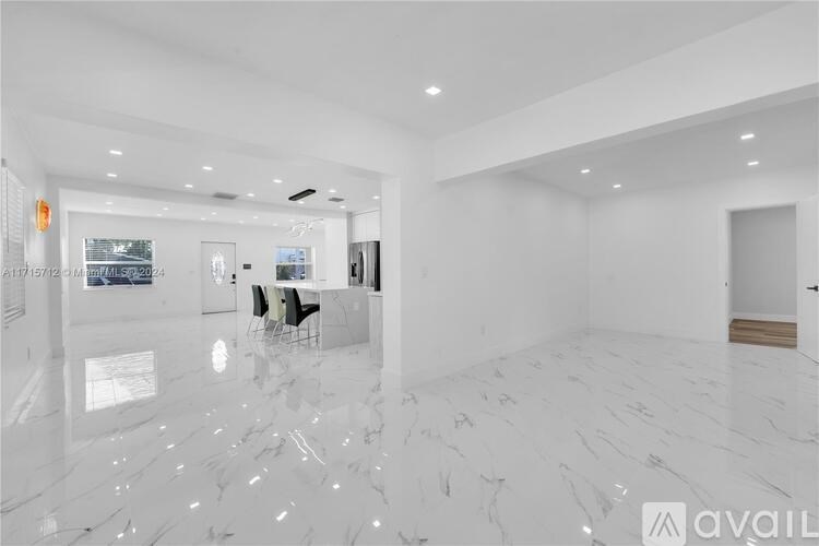 A spacious, white-walled room with a marble floor and a large mirror on the wall.