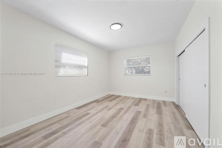 A room with wooden flooring and a white door.