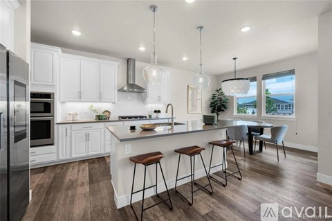 A kitchen with white cabinets and a wooden floor.
