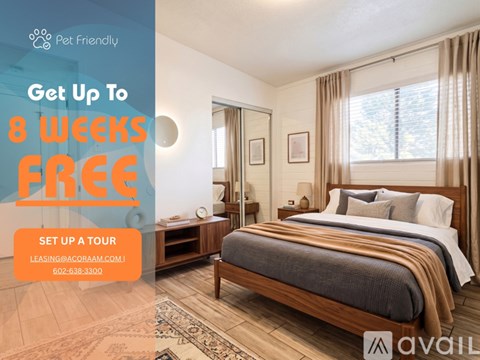 A living room with a couch, coffee table, and pictures on the wall, with a sign offering a free first month of rent.
