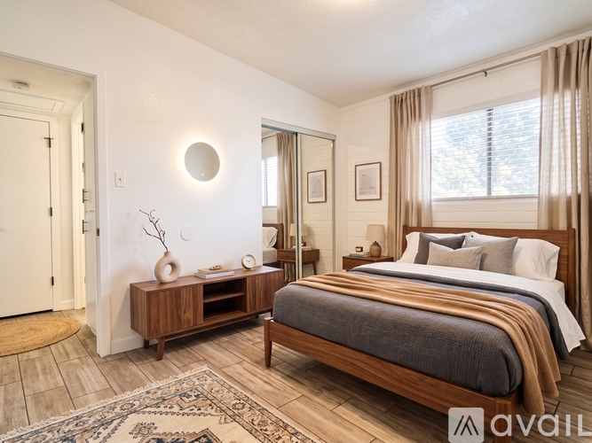 A bedroom with a large bed and a wooden dresser.