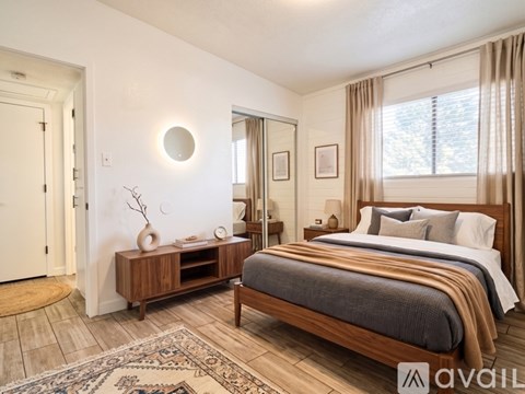 A bedroom with a large bed and a wooden dresser.
