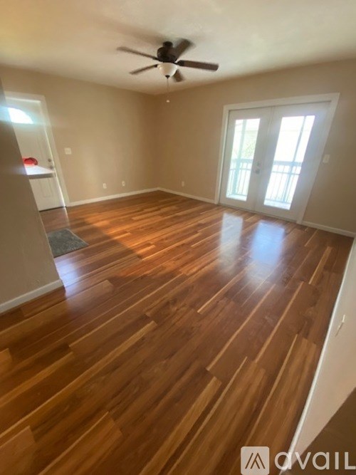 A room with wooden flooring and a ceiling fan.