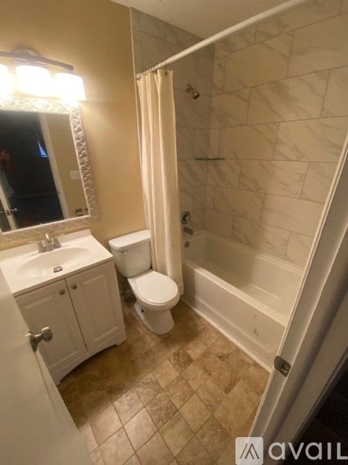 A bathroom with a toilet, sink, and shower.