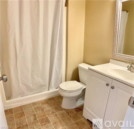 A white toilet sits next to a white sink in a bathroom.