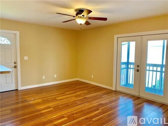 A room with a ceiling fan and wooden flooring.