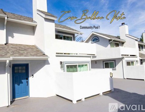 A white building with a blue door and the words "Cove Ballina View Community Pool!" written on the top.