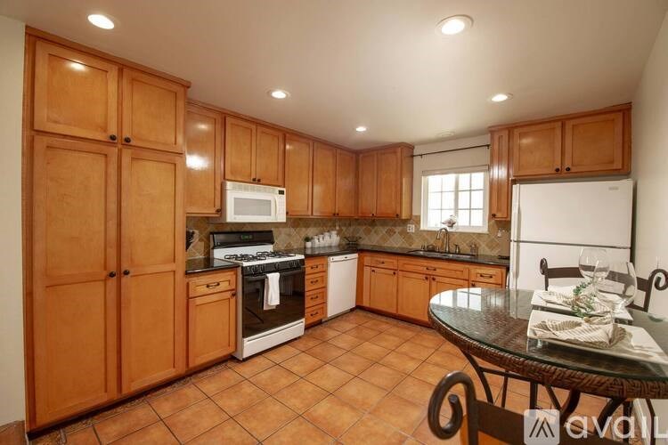 A kitchen with wooden cabinets and a tiled floor.