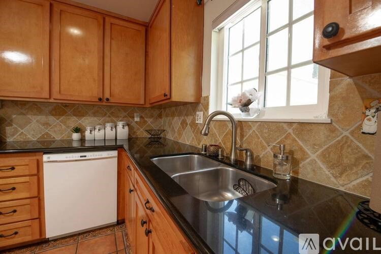 A kitchen with wooden cabinets and a black countertop.