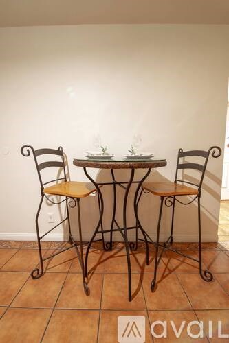 A table with two chairs and a plant on it.