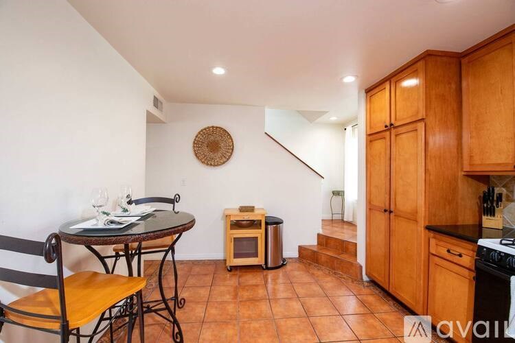 A kitchen with wooden cabinets and a tiled floor.