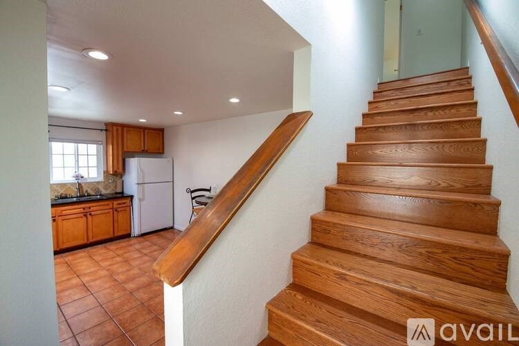 A wooden staircase leads up to a kitchen area.