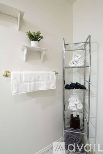 A white bathroom with a towel rack and shelves.
