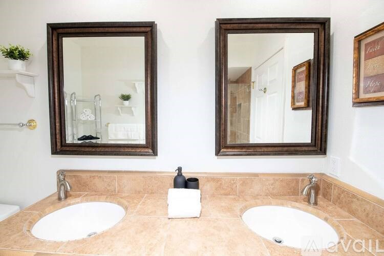 A bathroom with two sinks and two mirrors.