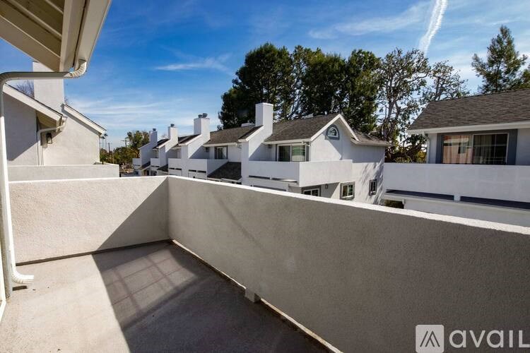 A balcony with a view of houses and trees.
