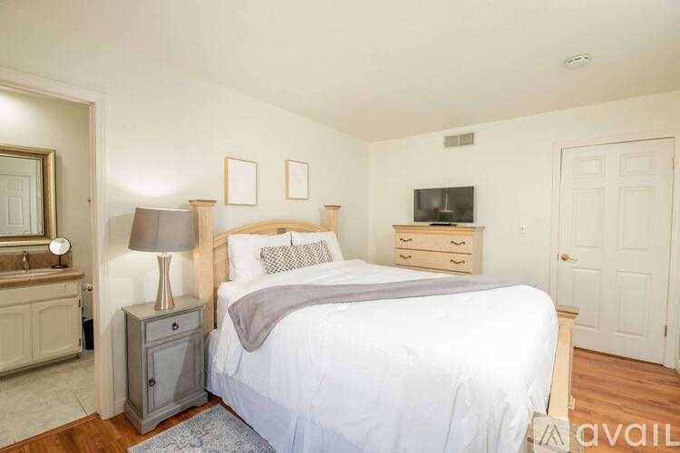 A bedroom with a bed, nightstand, and a cabinet.