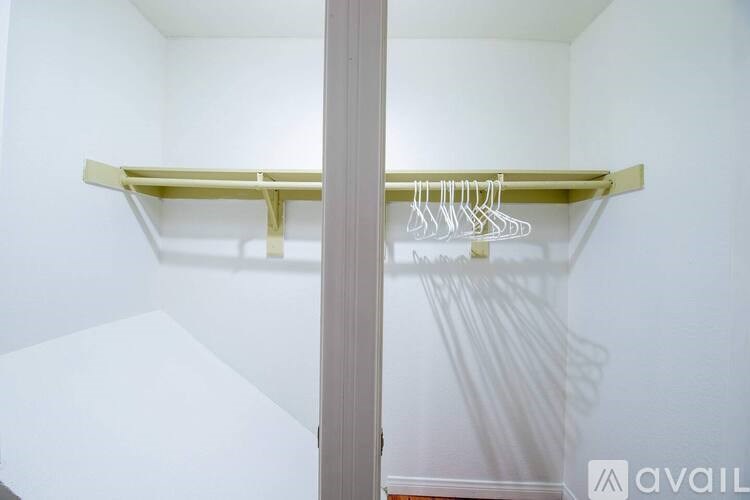 A white closet with a shelf and hangers.