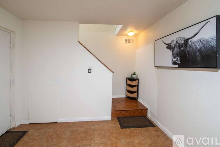 A room with a bull picture on the wall and a wooden floor.
