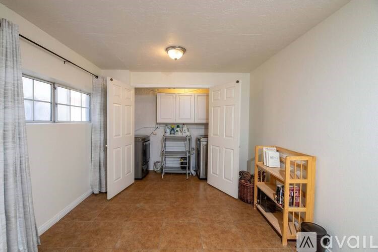 A room with a window, a bookshelf, and a dining table.