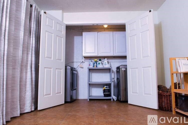 A kitchen with white cabinets and a refrigerator.
