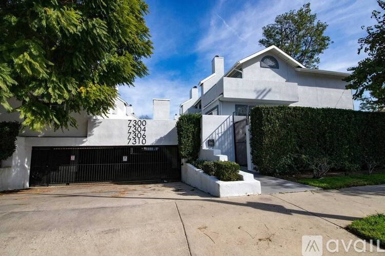 A modern house with a white exterior and a black garage door.