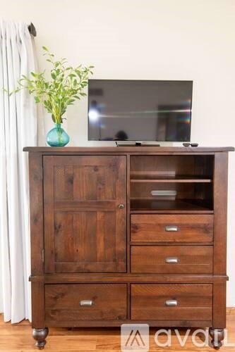 A wooden cabinet with a flat screen TV on top of it.