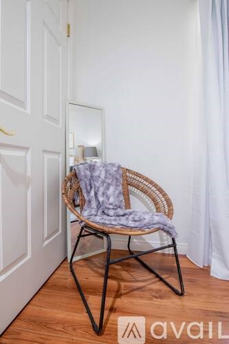 A chair with a purple blanket is in front of a mirror.
