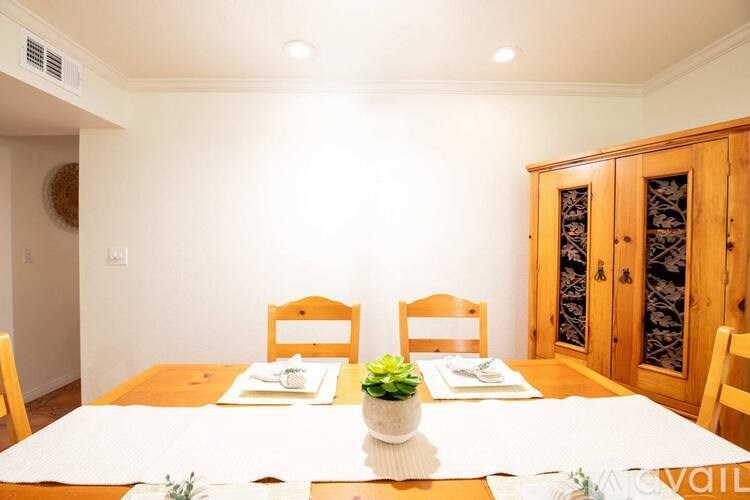 A dining room with a wooden table and chairs.