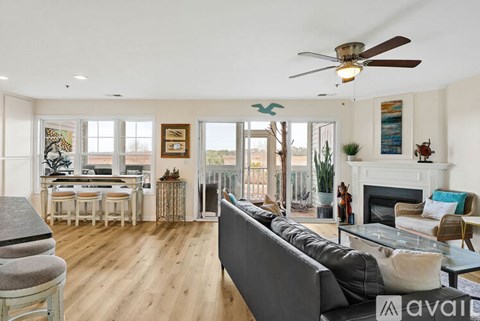 A living room with a grey couch and a fireplace.
