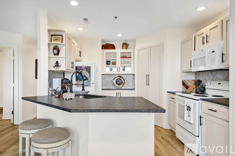 A kitchen with a black countertop and white cabinets.