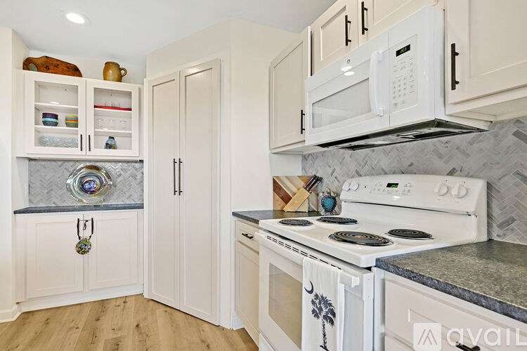 A kitchen with white appliances and cabinets.