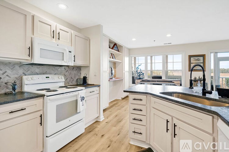 A kitchen with white appliances and cabinets.