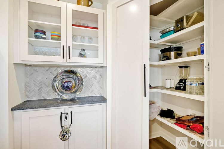 A kitchen with a white cabinet and a glass jar on top of it.