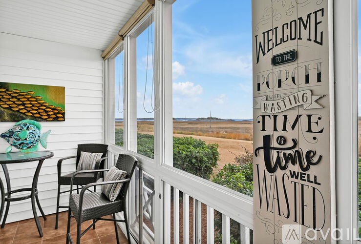 A balcony with a table and chairs and a sign on the wall.