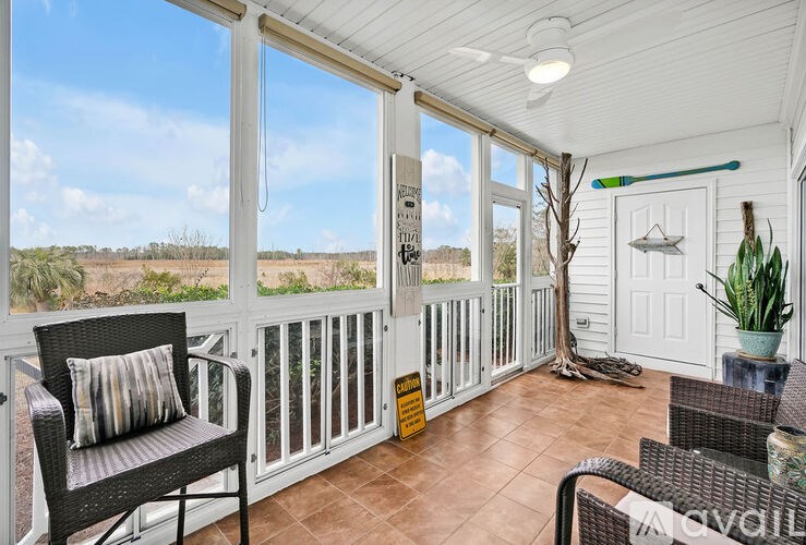 A sunroom with a chair and a table.