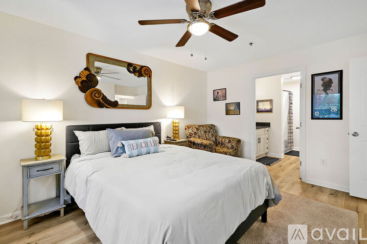A bedroom with a large bed and a mirror on the wall.