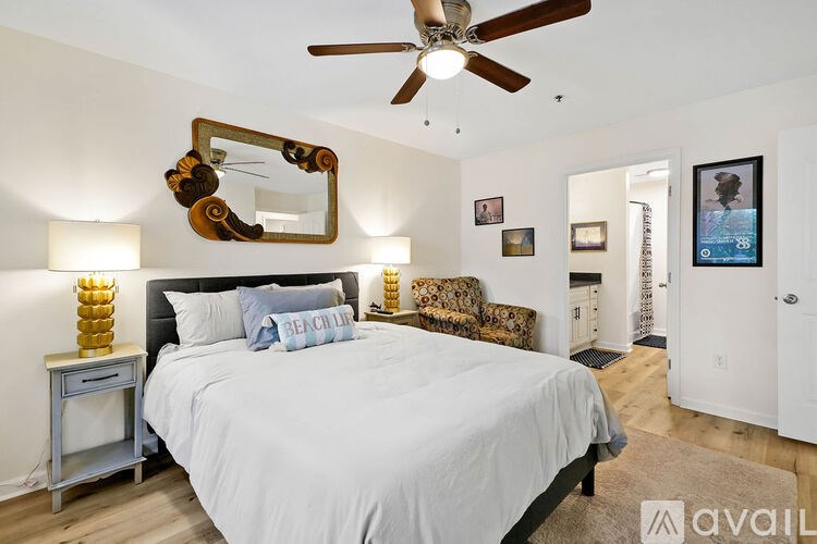 A bedroom with a large bed and a mirror on the wall.