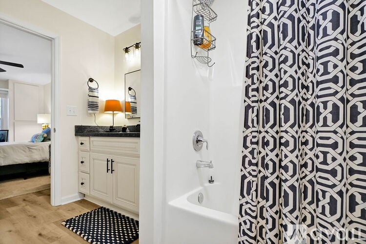 A bathroom with a black and white shower curtain.