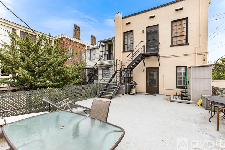 A backyard with a hot tub and a patio table.