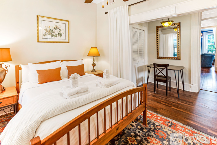 A bedroom with a large bed and a small table.